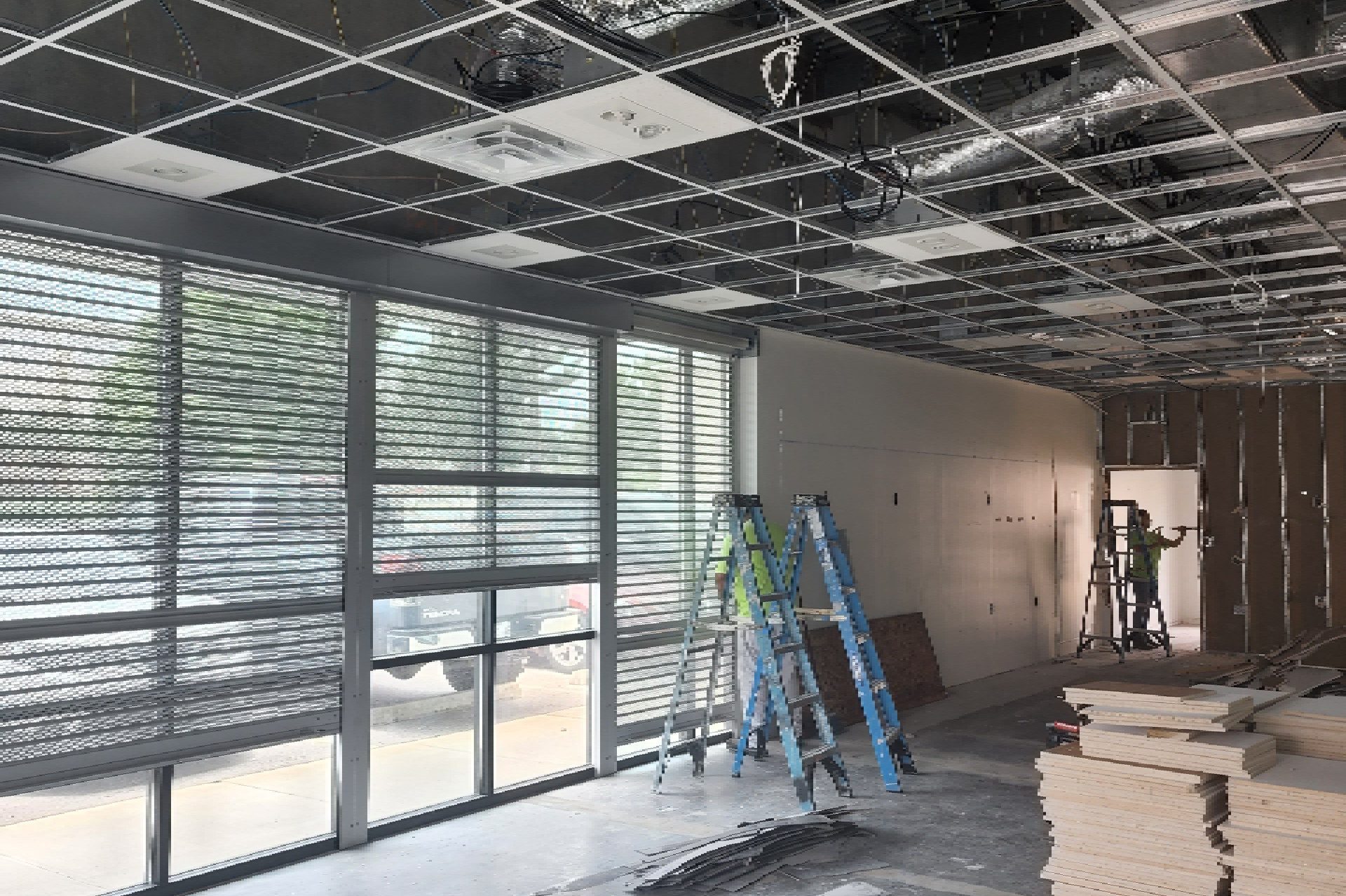 A construction worker is standing on a ladder, possibly working on the renovation or repair of the building