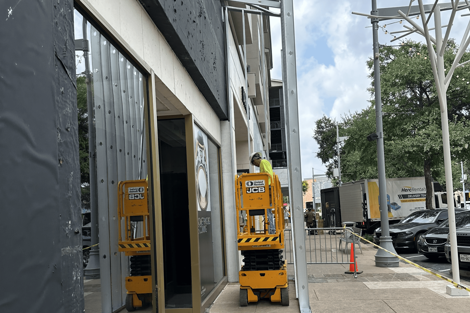 a yellow forklift truck parked in front of a building, likely a store or a warehouse